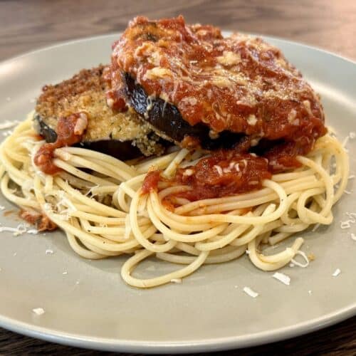 Fried Eggplant Parm and Pasta on a plate with marinara sauce and spaghetti