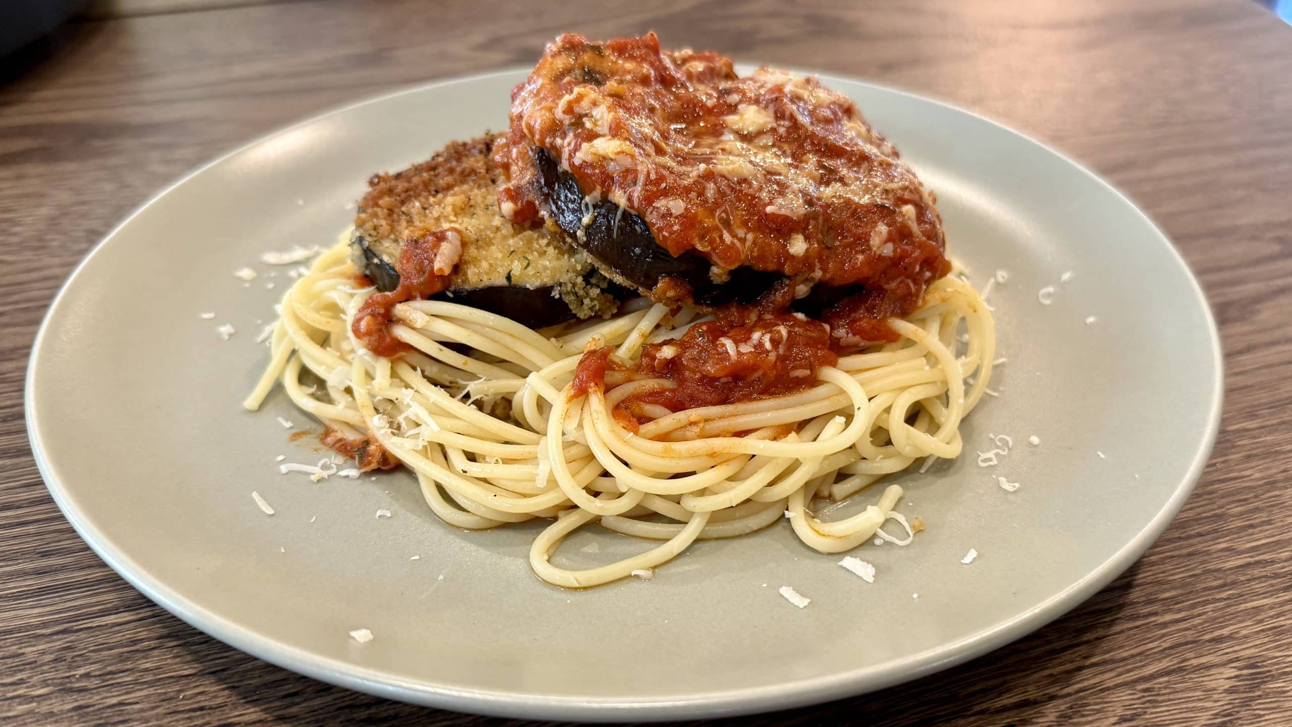 Fried Eggplant Parm and Pasta on a plate with marinara sauce and spaghetti