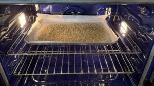 Sheet pan with seasoned panko breadcrumbs toasting in the oven for eggplant parmesan.